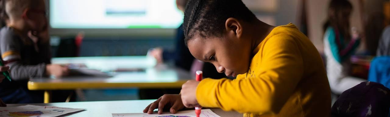 young student writing with a marker